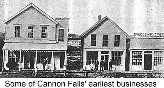 Black and white photo of several frame store-front buildings along a dirt street--some of the first businesses in Cannon Falls